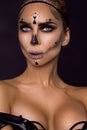 Portrait brunette woman in Halloween makeup on a black background in the studio. Make-up skeleton, monster and witch Royalty Free Stock Photo