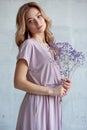 Portrait of a sexy charming woman in a white blouse with a flower in her hands