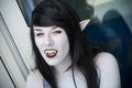 Portrait of sexy girl with dracula teeth and pointed ears at the geek cosplay convention