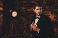 Portrait of sexy macho man wearing black tuxedo and bow-tie in loft Royalty Free Stock Photo