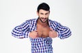 Portrait of a macho unbuttoning shirt
