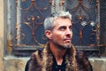 Portrait of a man in wolf fur and ornamental medieval window on background