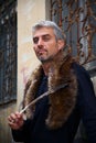 Portrait of a man and wolf furry and eagle feathers, and ornamental medieval window on background Royalty Free Stock Photo