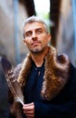 Portrait of a man and wolf furry and eagle feathers, and ornamental medieval window on background Royalty Free Stock Photo