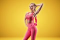 Portrait of a sexy sportswoman posing in the studio on a yellow background. Fitness concept