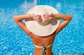 Portrait of sexy tanned slim model woman in colorful bikini and hat having relax and enjoying in swimming pool. Hot summer day and Royalty Free Stock Photo