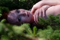 portrait of sexy young naked redhead blue eyed woman lying on forest floor between small spruce trees whose branches cast bizarre Royalty Free Stock Photo