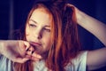 Portrait of sexy young woman touching long red hair. Female model posing in the studio, face close-up Royalty Free Stock Photo