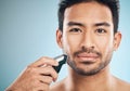 Portrait, shave and electric razor with a man in studio on a blue background for personal hygiene or grooming. Face Royalty Free Stock Photo