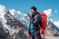 Portrait of Sherpa man with backpack using walkie-talkie for calling rescue helicopter with Mera peak 6476m background.High