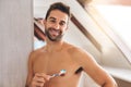 Portrait, shirtless and happy man brushing teeth in bathroom for dental wellness, healthy smile and body with care at Royalty Free Stock Photo