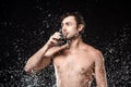 portrait of shirtless man drinking water from glass while swilled with water