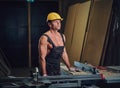 Portrait of shirtless muscular carpenter.