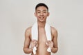 Portrait of shirtless young asian man with problematic skin and hyperpigmentation on his face posing with towel around