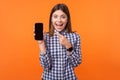 Portrait of shocked attractive brunette woman with charming smile. indoor studio shot isolated on orange background Royalty Free Stock Photo