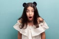 Portrait of shocked beautiful brunette young girl with black long straight hair in white dress standing and looking at camera with Royalty Free Stock Photo