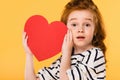 portrait of shocked child with red paper heart