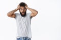 Portrait of shocked freak-out african american male in glasses grabbing hair open mouth folding lips and raising