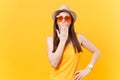 Portrait of shocked fun crazy young woman in straw summer hat, orange glasses cover mouth hand, copy space isolated on