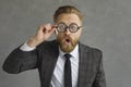 Portrait of shocked and funny caucasian businessman in glasses with magnifying glass. Royalty Free Stock Photo