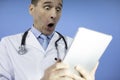 Portrait of shocked male doctor with stethoscope looking at laptop