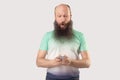 Portrait of shocked middle aged bald bearded man looking at mobile smart phone display with surprised face. reading good news or Royalty Free Stock Photo