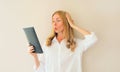 Portrait of shocked and surprised caucasian young woman employee looking at digital tablet computer or folder with documents, Royalty Free Stock Photo