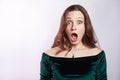 Portrait of shocked woman with freckles and classic green dress.