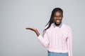 Portrait of shocked woman holding copyspace on palm looking at camera isolated on grey background Royalty Free Stock Photo