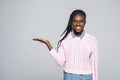 Portrait of shocked woman holding copyspace on palm looking at camera isolated on grey background Royalty Free Stock Photo