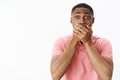 Portrait of shocked worried and concerned insecure african american young man holding hands on mouth gasping feeling Royalty Free Stock Photo