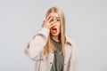 Portrait of shocked young blonde woman covering face with hand, hear bad news, problem trouble, wears casual clothes, stands Royalty Free Stock Photo