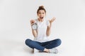 Portrait of a shocked young girl holding alarm clock Royalty Free Stock Photo