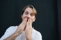 Portrait of a shocked young man covering his mouth with hands Royalty Free Stock Photo