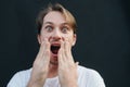 Portrait of a shocked young man covering his mouth with hands Royalty Free Stock Photo