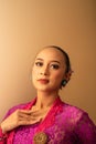 Portrait Shoot of Beautiful Balinese Women Preparing for the praying ritual while wearing pink dresses and gold badges