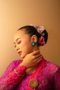 Portrait Shoot of Beautiful Balinese Women Preparing for the praying ritual while wearing pink dresses and gold badges