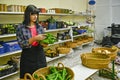 Portrait of shopkeeper in greengrocer's, sorting green peppers. Royalty Free Stock Photo