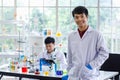 Portrait shot of Asian professional successful young handsome male scientist in white lab coat rubber gloves standing crossed arms Royalty Free Stock Photo