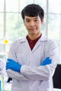 Portrait shot of Asian professional successful young handsome male scientist in white lab coat rubber gloves standing crossed arms Royalty Free Stock Photo