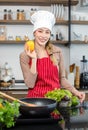 Portrait shot of Asian young beautiful female chef housewife wears white tall cook hat and apron standing smiling posing with Royalty Free Stock Photo