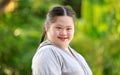 Portrait shot of Asian young chubby down syndrome autistic autism little cute schoolgirl with braid pigtail hairstyle model stand Royalty Free Stock Photo