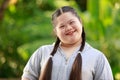 Portrait shot of Asian young chubby down syndrome autistic autism little cute schoolgirl with braid pigtail hairstyle model stand Royalty Free Stock Photo