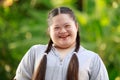 Portrait shot of Asian young chubby down syndrome autistic autism little cute schoolgirl with braid pigtail hairstyle model stand Royalty Free Stock Photo