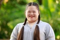 Portrait shot of Asian young chubby down syndrome autistic autism little cute schoolgirl with braid pigtail hairstyle model stand Royalty Free Stock Photo