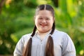 Portrait shot of Asian young chubby down syndrome autistic autism little cute schoolgirl with braid pigtail hairstyle model stand Royalty Free Stock Photo