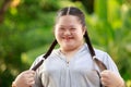 Portrait shot of Asian young chubby down syndrome autistic autism little cute schoolgirl with braid pigtail hairstyle model stand Royalty Free Stock Photo