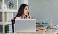 Portrait shot of Asian young professional successful female doctor practitioner wearing white lab coat with stethoscope sitting in Royalty Free Stock Photo