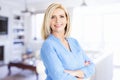 Portrait shot of beautiful elderly woman with toothy smile standing inside