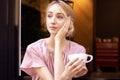 Close-up portrait shot of happy young woman drinking coffee at the cafe and daydreaming Royalty Free Stock Photo